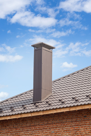New chimney (smokestack) on the metal tile roofの写真素材