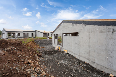 Construction of building of new white concrete house with incomplete wooden roofの写真素材