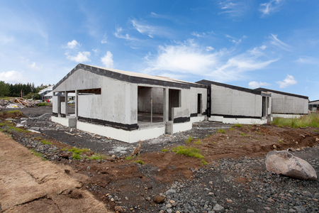 Construction of building of new white concrete houses with incomplete wooden roofの写真素材