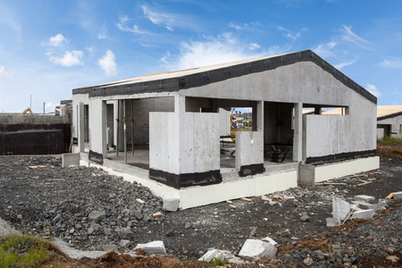 Construction of building of new white concrete house with incomplete wooden roofの写真素材