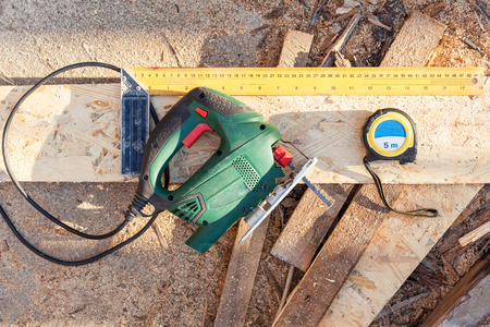 Jig saw, construction roulette, ruler. Instruments for cutting a Wood Particle Board (fiberboard)の写真素材
