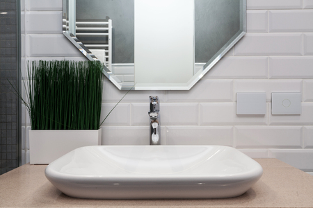 Bathroom interior. Bright bathroom with new tiles. New washbasin, white sink and large mirrorの写真素材