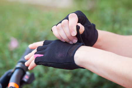 The girl dresses and fastens her bicycle gloves.の写真素材