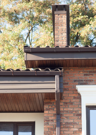 Rain gutter on a modern brick house with plastic windows