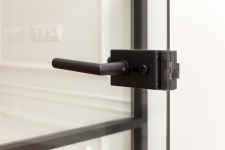 Glass door with metallic handle open in to the empty roomの写真素材