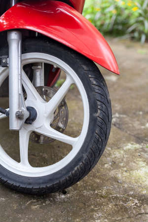 Fragment of front wheel with disc brakes of a red scooterの写真素材