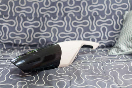 Small vacuum cleaner on the couchの写真素材