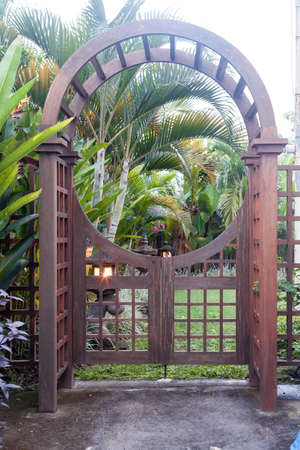 Wooden arbor with close gate in garden. Wooden arched entrance to the backyardの写真素材