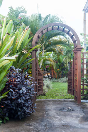 Wooden arbor with gate in garden. Wooden arched entrance to the backyardの写真素材