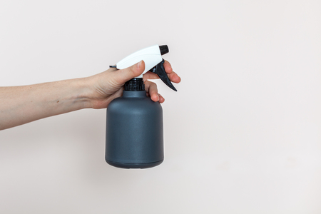 Girl hold a spray for flowers in her hand on a light backgroundの写真素材