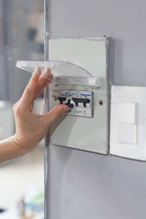 Woman hand  turning off fuse box in the houseの写真素材