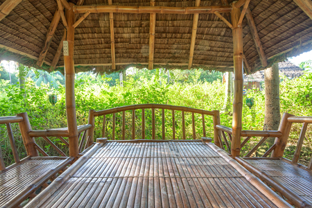 Large wooden garden house with table and benches for rest. Inside of gazebo under constructionの写真素材