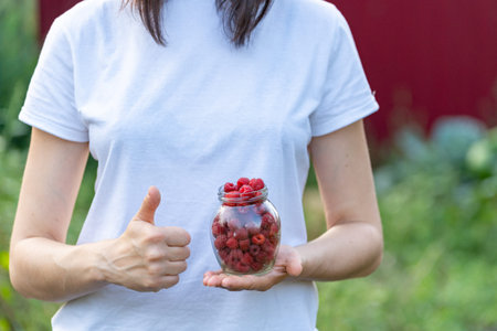 Advertising concept. Close up cropped photo of lady in white t-shirt holds transparent container...