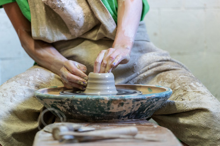 Close up cropped photo of lady in her workwear she sit inside workspace production ceramics clay product by hands enjoy processの写真素材