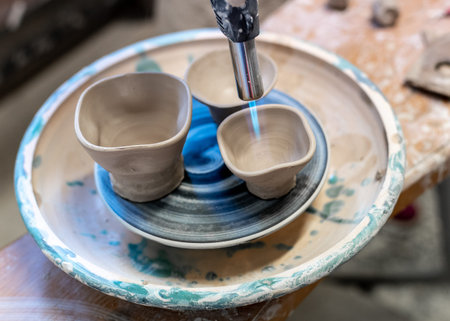 Master class concept. Cropped close up photo of lady using blowtorch to finish her small ceramics...