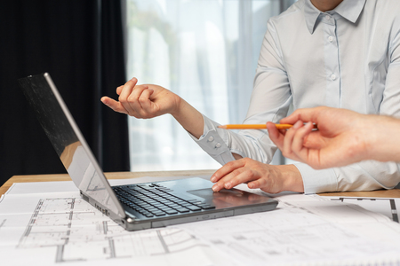 Profile side view photo of cropped two cooperation professional designer person in formal wear sit at the desk in bright loft interior hold pencil in hand pointer on netbook monitorの写真素材