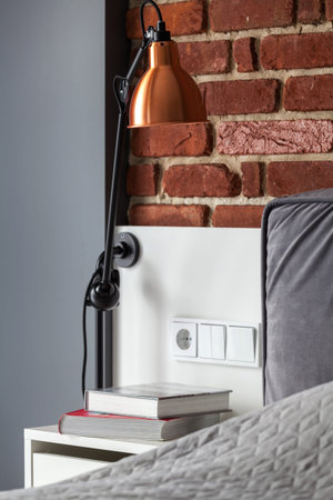 Vertical photo of expensive interior in rest room. Soft gray bad standing near loft brisk wallの写真素材