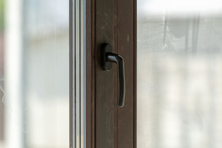 Close up photo of handle on closed plastic windowの写真素材
