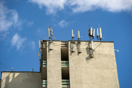 Photo of few single panel antennas of cellular systems on a steel mast at the roof of buildingの写真素材