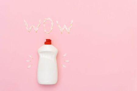 White soap bottle lying under signature WOW isolated on pastel pink background with empty space for...