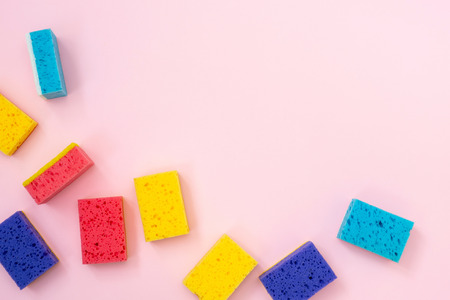 Colorful polyurethane dish sponges for washing laying isolated on pastel pink background with empty space for textの写真素材