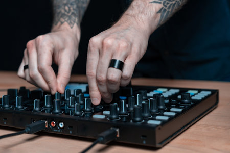 Close-up and cropped photo tattoo hands of professional DJ man creative music inside house room...