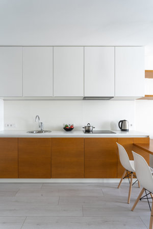 Vertical photo of bright light and white modern kitchen room with contemporary interior in cozy flat