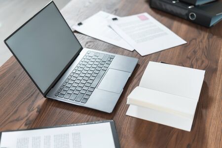 High angle view of modern laptop, documents and organizer with copy space on wooden table in officeの写真素材