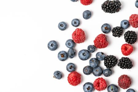 Top view and close up of mix ripe, yummy and sweet blueberries, blackberries, raspberries fruits on white background with copy spaceの写真素材