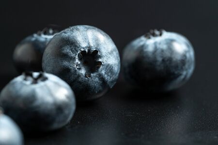 Selective focus and close up view of ripe blueberries fruit on black background with copy spaceの写真素材