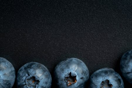 Top view and close up of macro ripe blueberries fruit on black background with copy spaceの写真素材