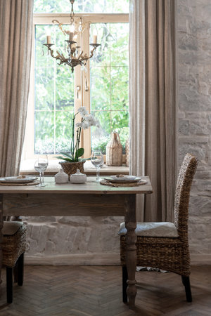 Vertical photo of cozy house with wooden interior design. Holiday table setting for two person with...