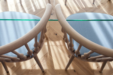 High angle top view of glass table and wooden chair standing on laminate floor with wood texture....