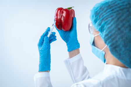 Microbiology engineer. Back view of laborant woman in coat working on clinical experiment, holding...