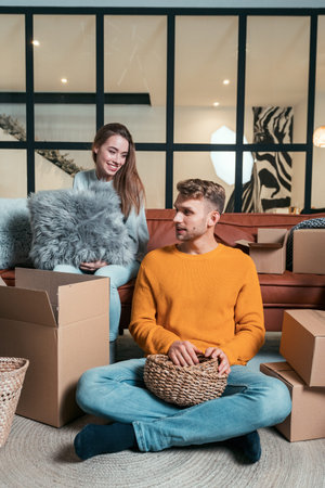 Real estate concept. Vertical photo of happy young adult man and woman move in new house together,...