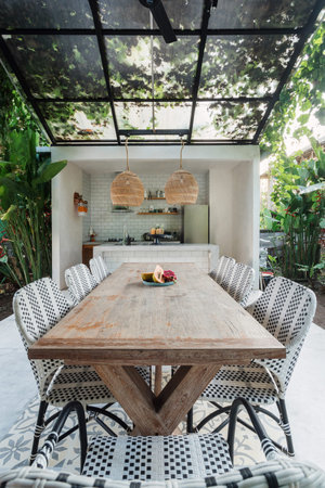Vertical photo of glass roof over dining room table and chairs on modern open kitchen with greenery on backgroundの写真素材