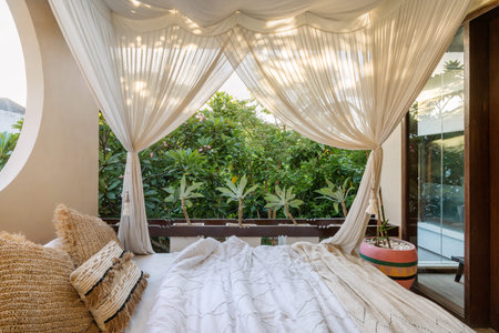 Elegant and modern open space bedroom with baldachin over bed, large windows full fresh and natural...