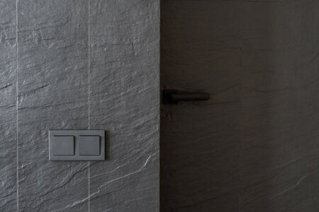 Copy space of electric light switch on grey copy space wall. Element of contemporary interior design with closed door and minimalist handleの写真素材