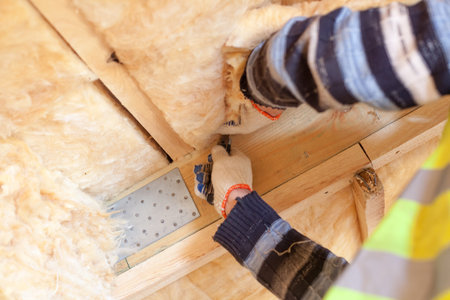 Concept of building under construction. Cropped view of professional workman holding knife tool in...
