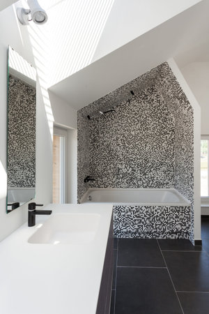 Vertical view of modern house with contemporary interior design in bathroom, white tub, sink on...