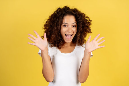 Portrait of excited happy young african american woman screaming loud, having fun, holding hands...