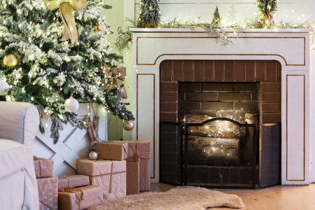 Lovely living room with garland in decorative fireplace, christmas presents under new year tree and home decor in modern apartment with cozy interior design