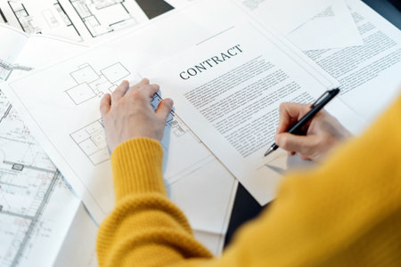High angle view of woman reading contract, sitting behind table with project plan, analyzing real estate market, mortgage loan with low rate and signing agreement for buying propertyの写真素材