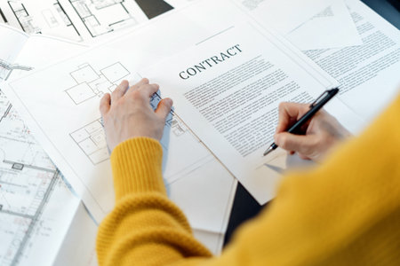 High angle view of woman reading contract, sitting behind table with project plan, analyzing real estate market, mortgage loan with low rate and signing agreement for buying property