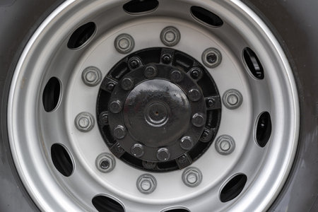 Close up view of metal bolt on new wheel. Concept of maintenance agrarian machinery. Replace and...