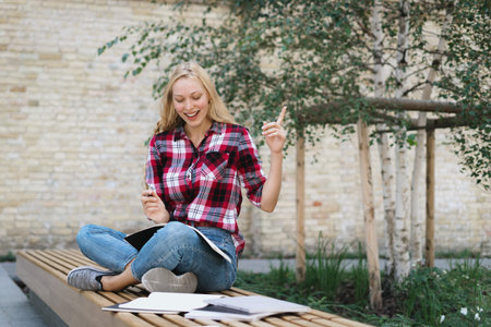 Education concept. Happy and smart academy student girl showing idea sign, making homework, writing...