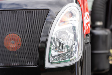 Close up shot of headlight attached to the front of vehicle to illuminate the road ahead. Turn...