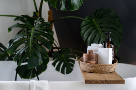 Wooden shelf for beauty and body care products at wooden shelf over modern white bathtub. Cozy boho...