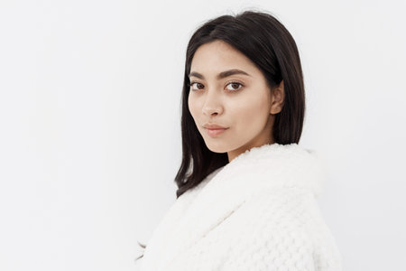 Pure beauty. Portrait of young attractive asian woman with clear healthy skin in white bathrobe...
