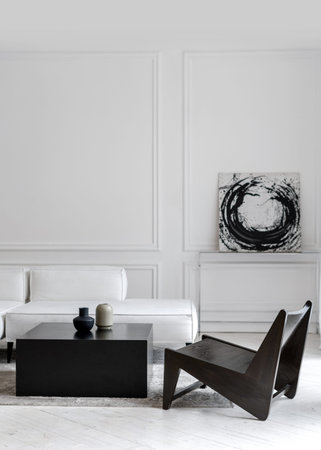 Vertical shot of stylish white comfy leather sofa in empty lounge zone with black futuristic chair...